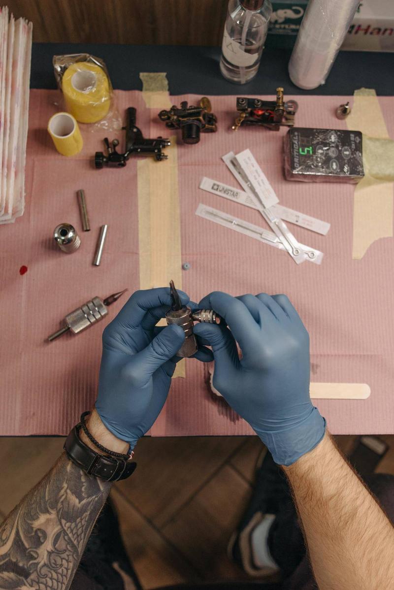 Gloved hands prepares tattoo supplies