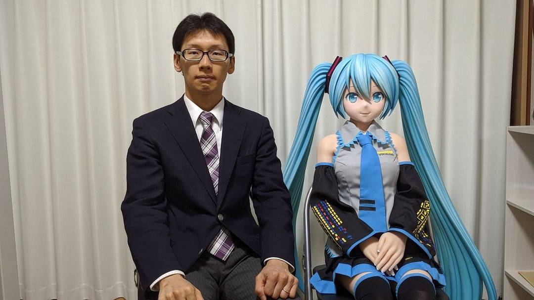 Akihiko Kondo and his bride sit on chairs