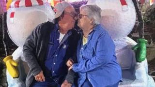 A photograph of an elderly man and woman kissing.