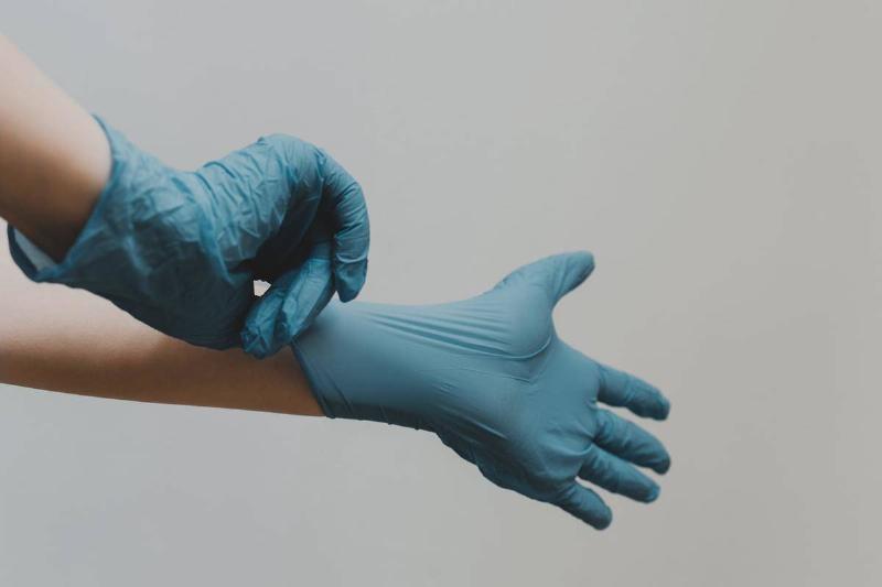 Hands In Blue Vinyl Gloves
