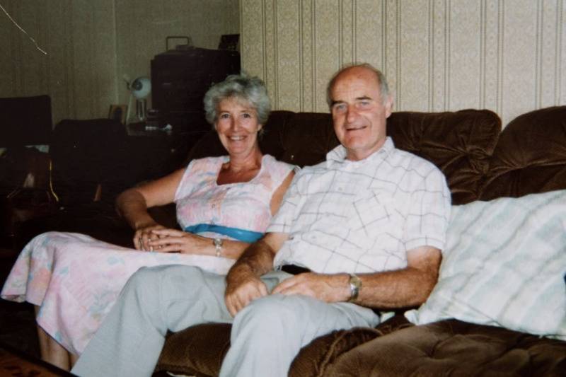Glyndwr and Audrey in the 1990s smiling sitting on a couch 
