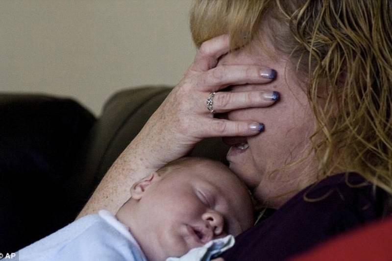 Distraught: Diana Phillips, Jenni Lake's mother, cries while holding her son as she remembers how strong she was throughout her lengthy battle with cancer