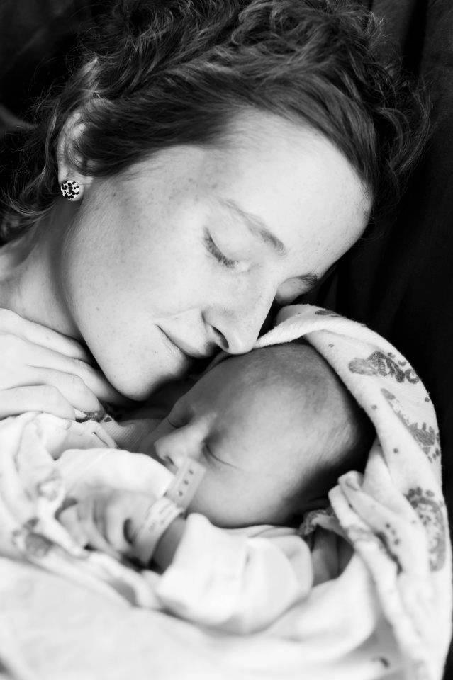 Jenni holding her baby in blanket in black and white