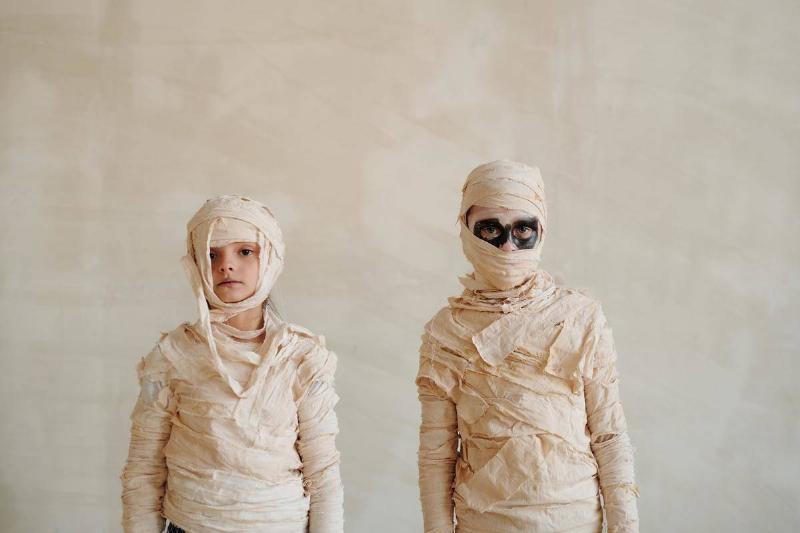 Two Children Dressed Up As Wrapped Mummies.