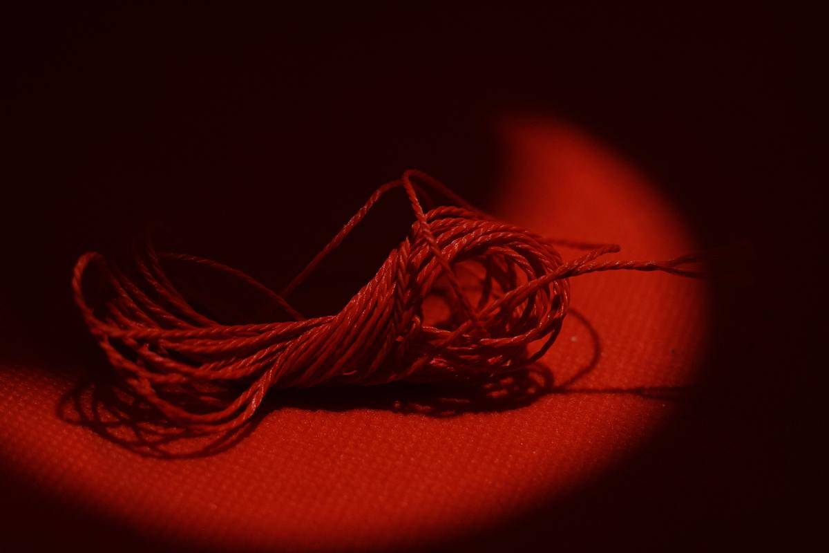 Red tied up string on red background