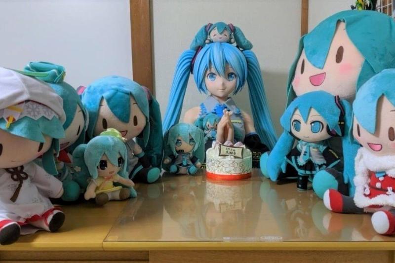 anime toys and replicas at birthday party sitting around table with cake