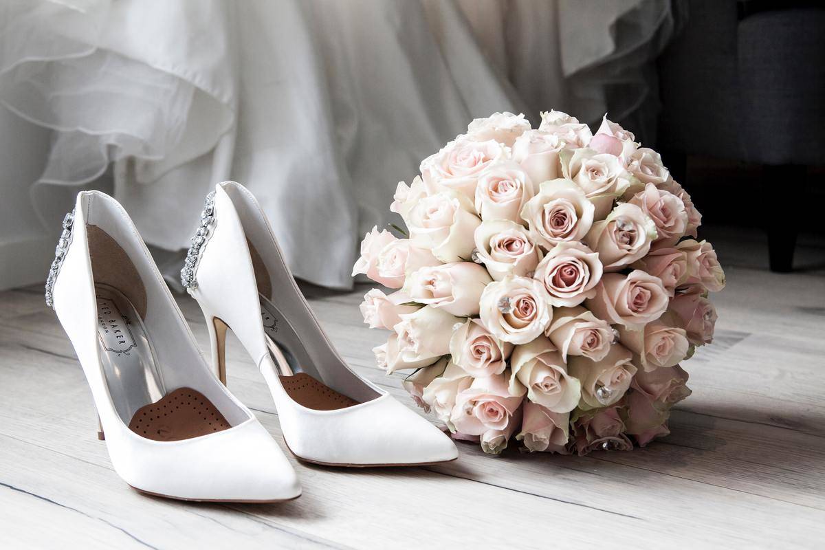 white heels and a bouquet of flowers