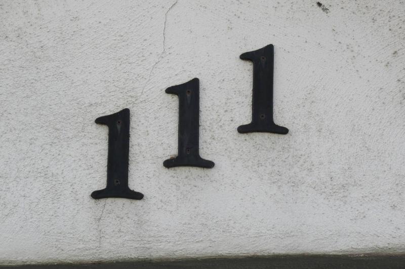 The number 111 painted on a stone wall