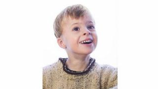 A young boy smiling with his teeth.