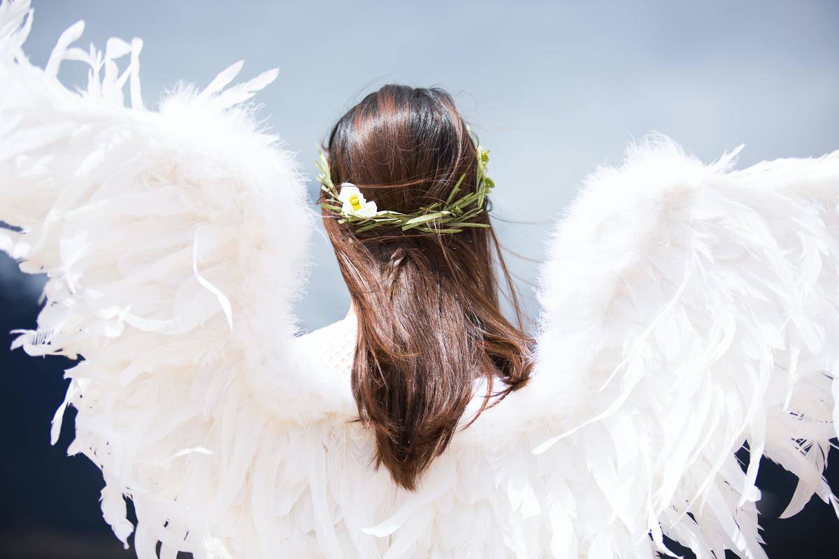 A woman with angel wings, from behind.