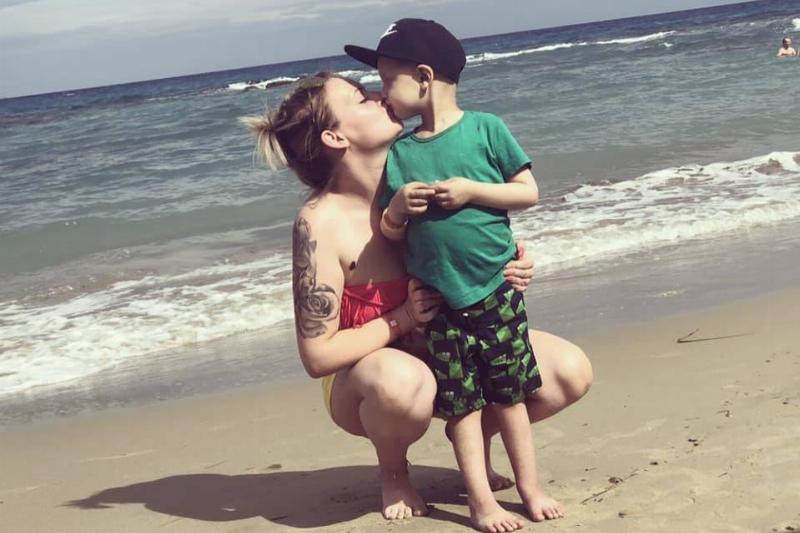 Beach Day A mother kissing her small son on a beach.