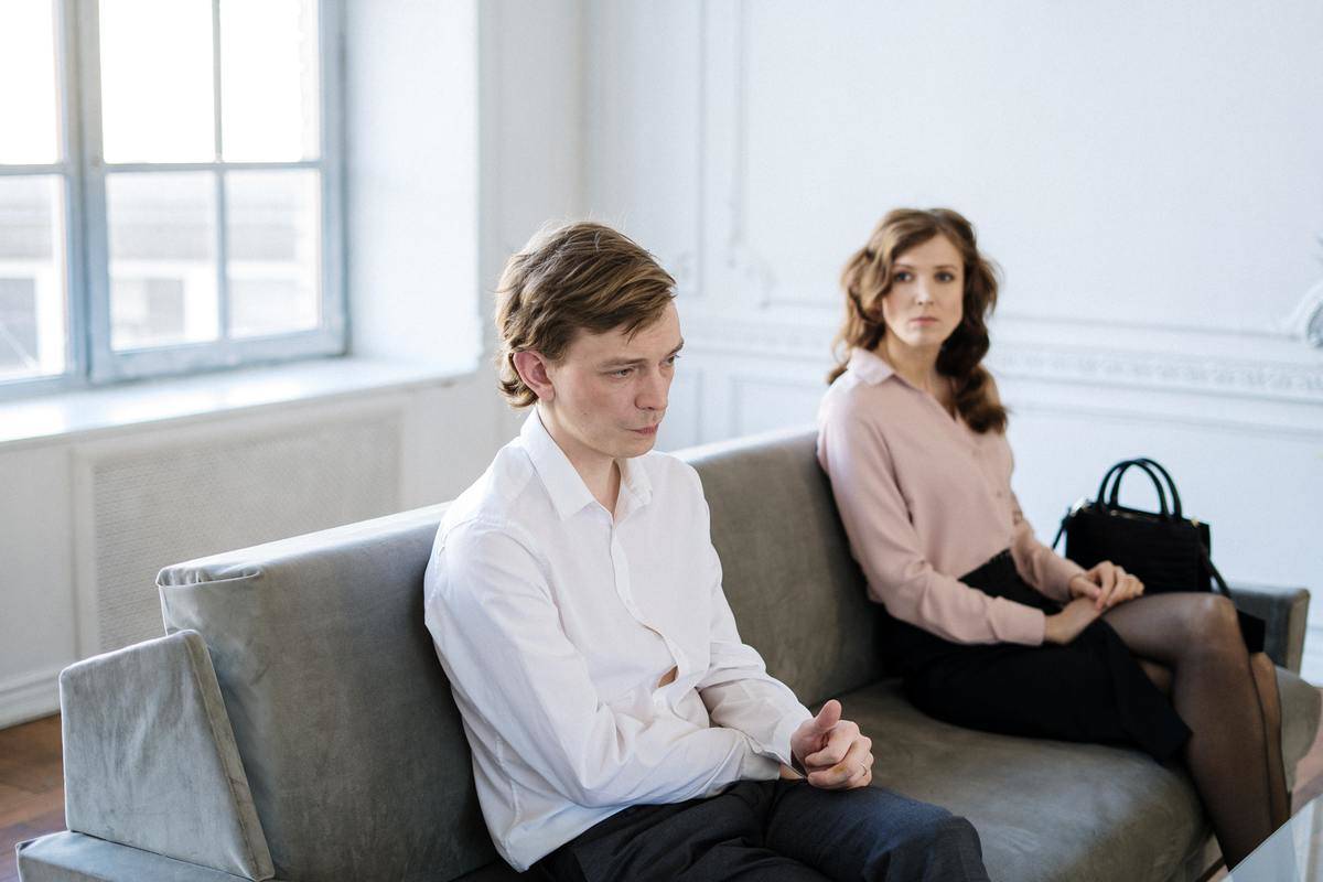 man and woman sitting on couch for cunselling