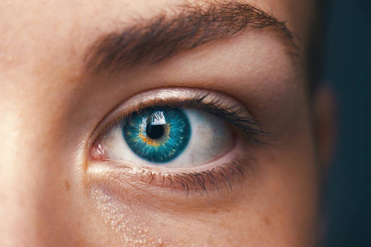 A close-up of a woman's face, focused on a bright blue eye.