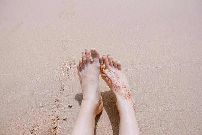 Bare foot laying in the sand.