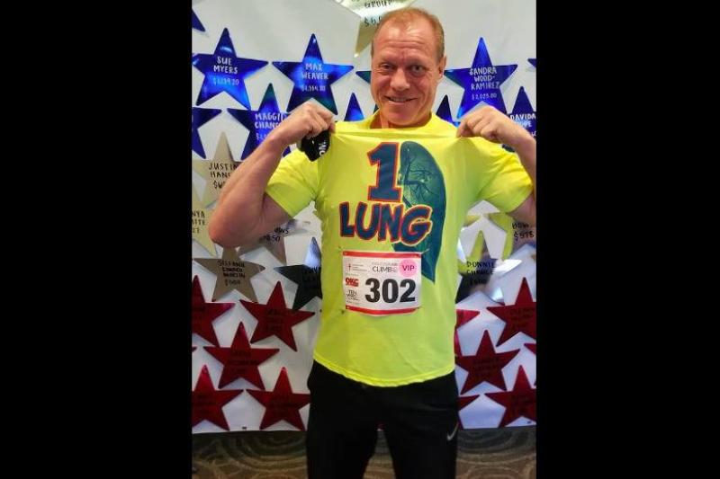 A man after running a marathon wearing a shirt that says 