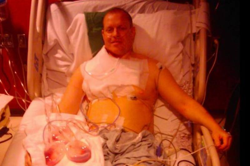A man in a hospital bed after an operation.