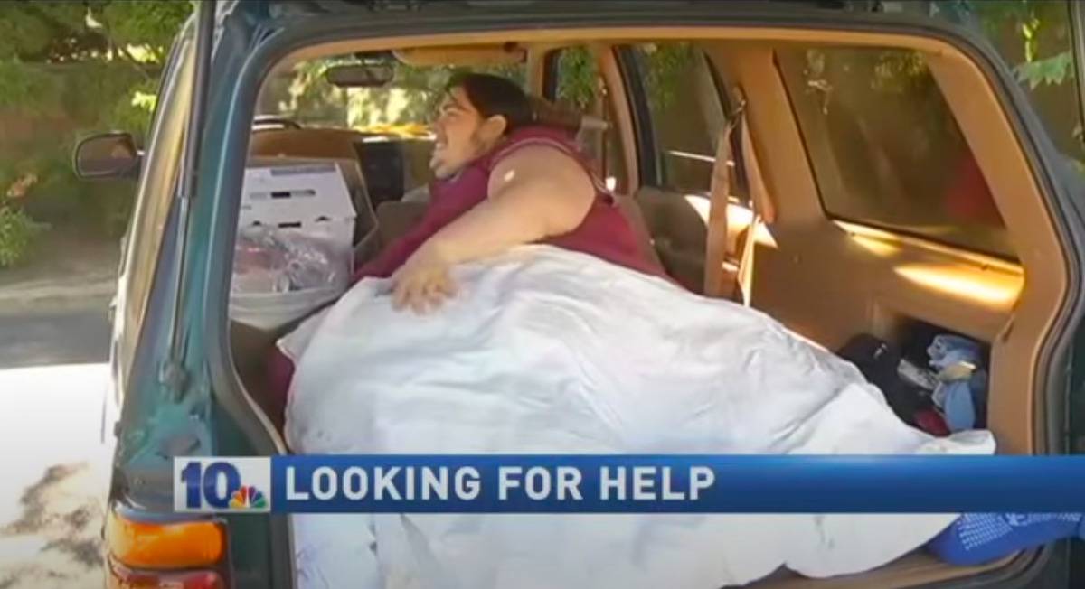 An obese man lying inside an SUV.