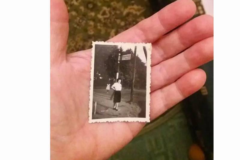 An old photograph held in someones hand.