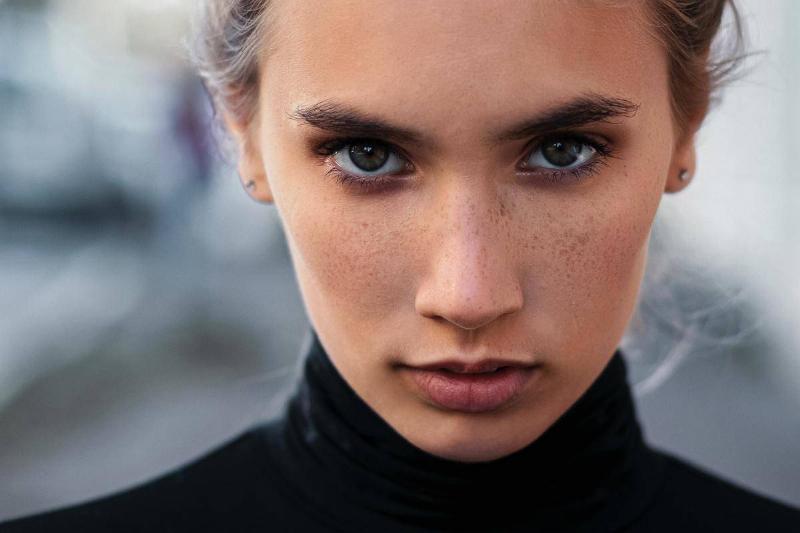 A woman wearing a black turtle neck staring deeply into the camera.