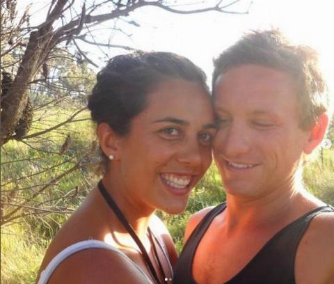 A man and woman taking a selfie on a hike.