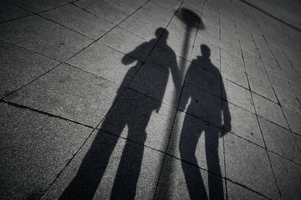 A shadow of two men walking hand in hand