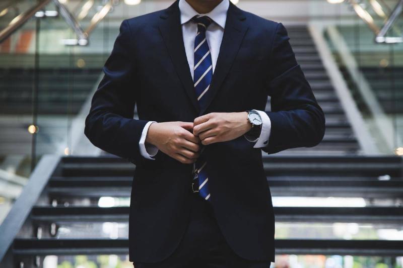 The Suit A man, from the collar bone down, dressed in business attire.