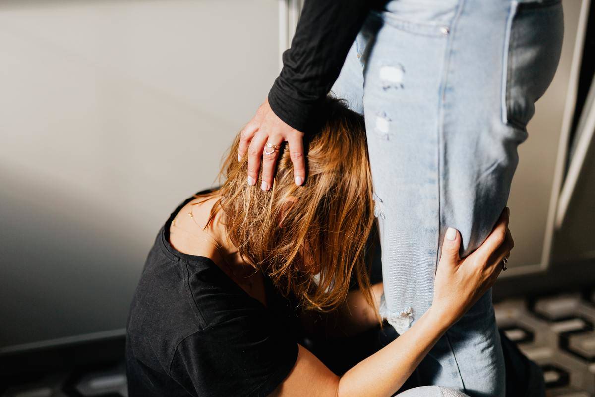 woman-in-black-shirt-crying- at the knees of man holding her head