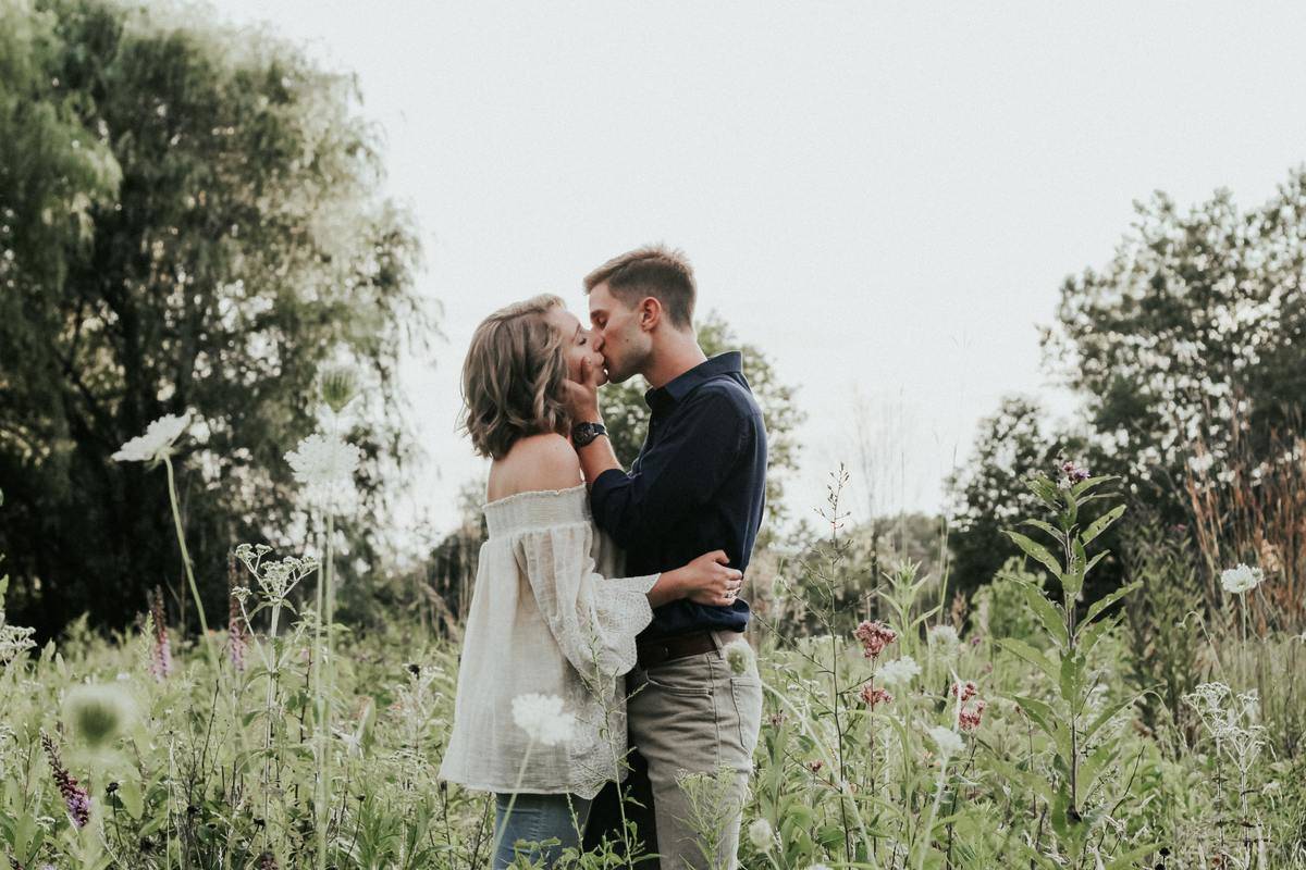 couple kiss in field standing