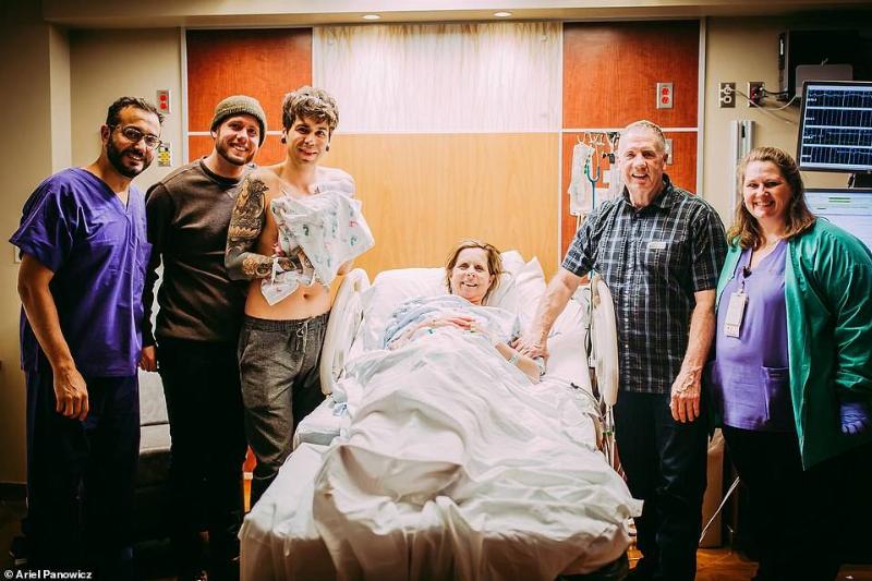 family around hospital bed smiling for photo