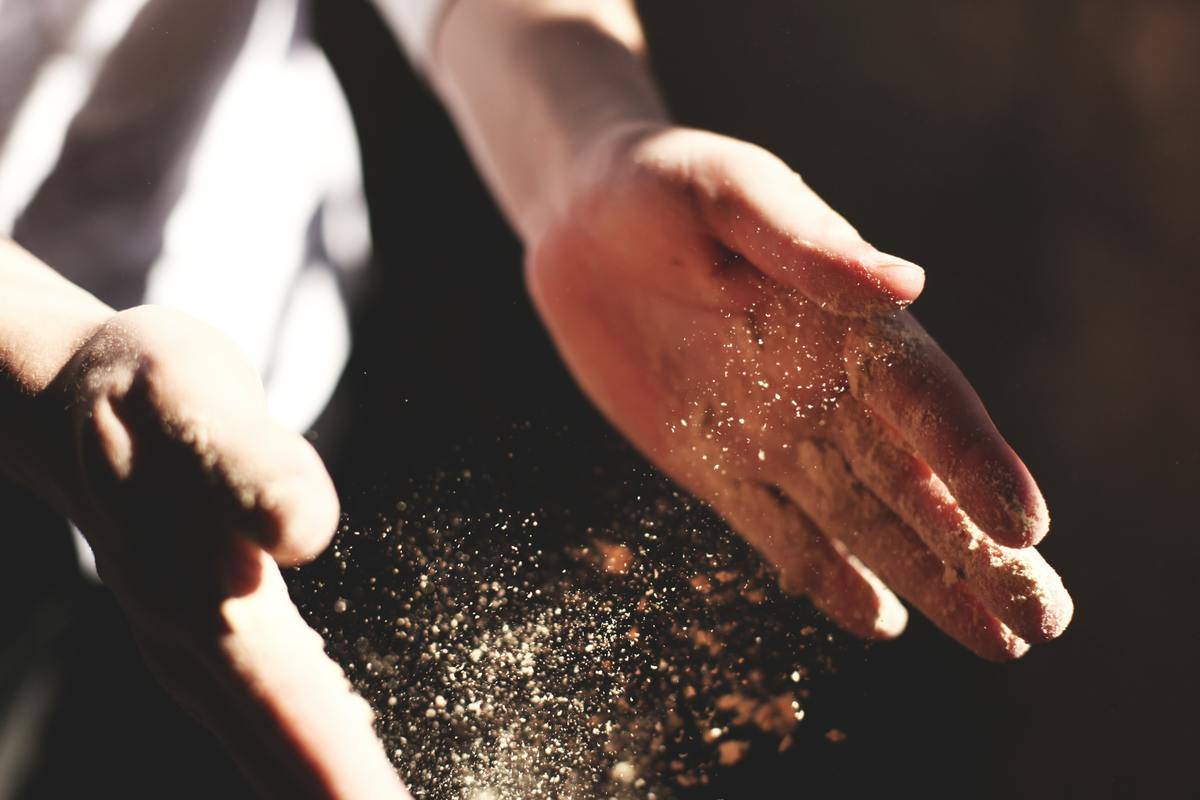close up of hands letting go of dust