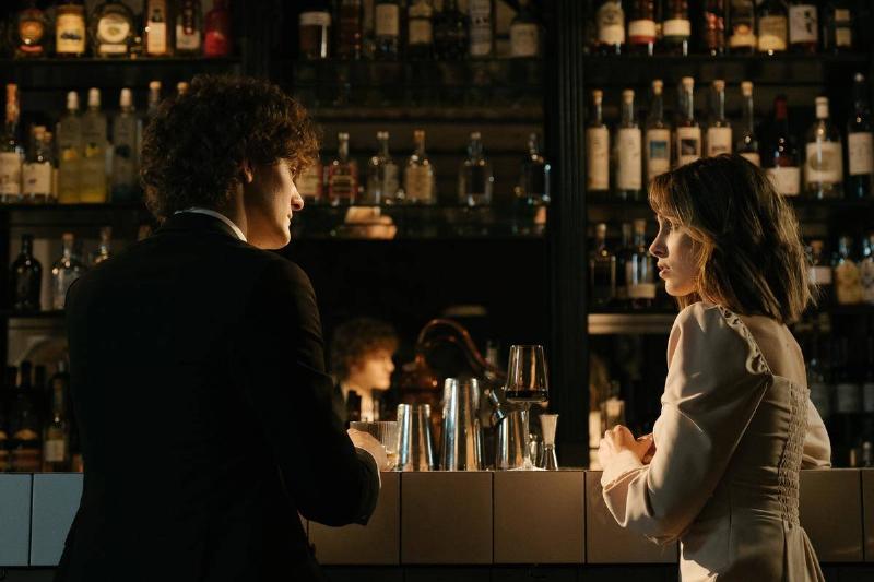 man and woman sit at a bar talking