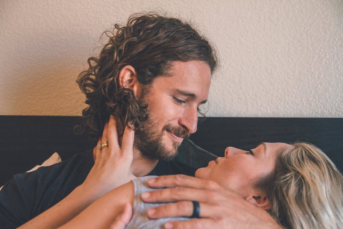 man holds woman affectionately while smiling down at her