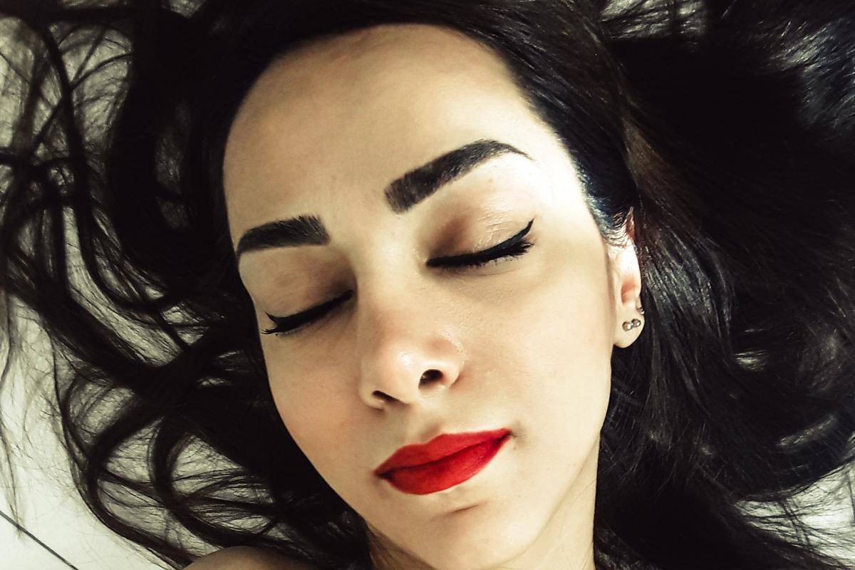 woman with red lipstick and eyes closed