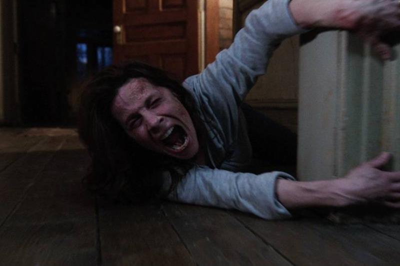 The Conjuring official screen capture. of Lili Taylor holding on to door