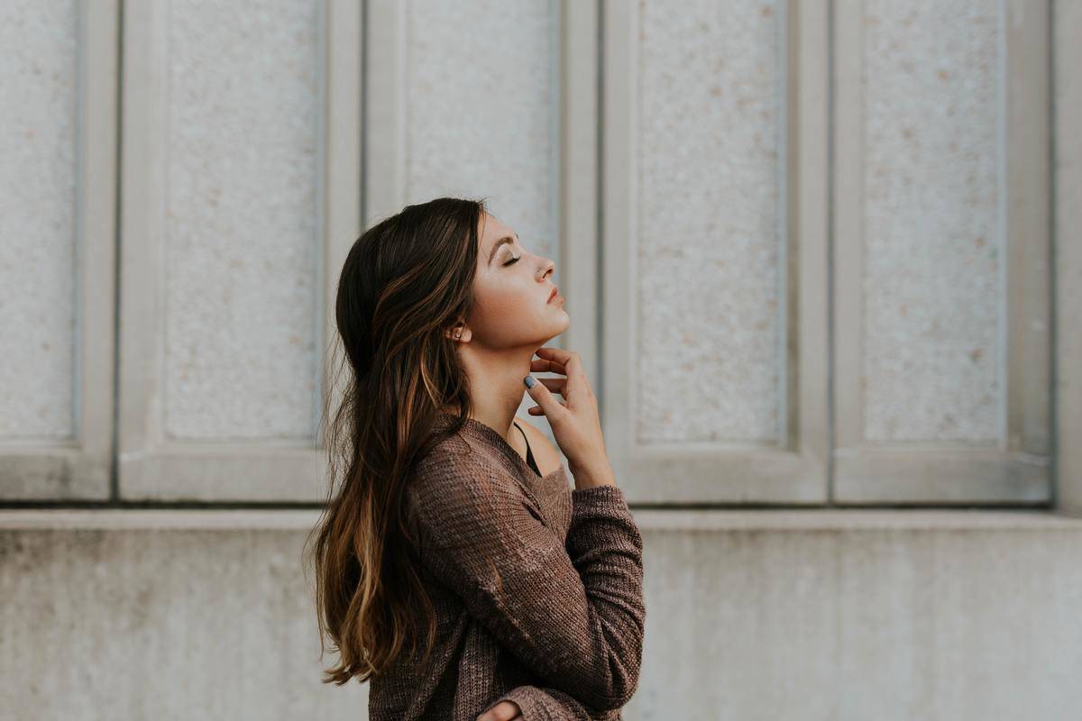 woman closing eyes and looking up in hope