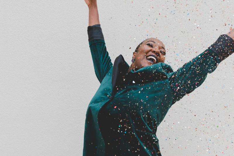 woman jumps of joy with sprinkles around her