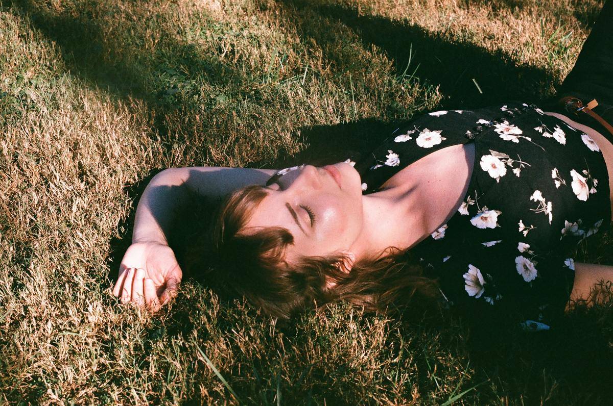 woman laying on the grass with eyes closed