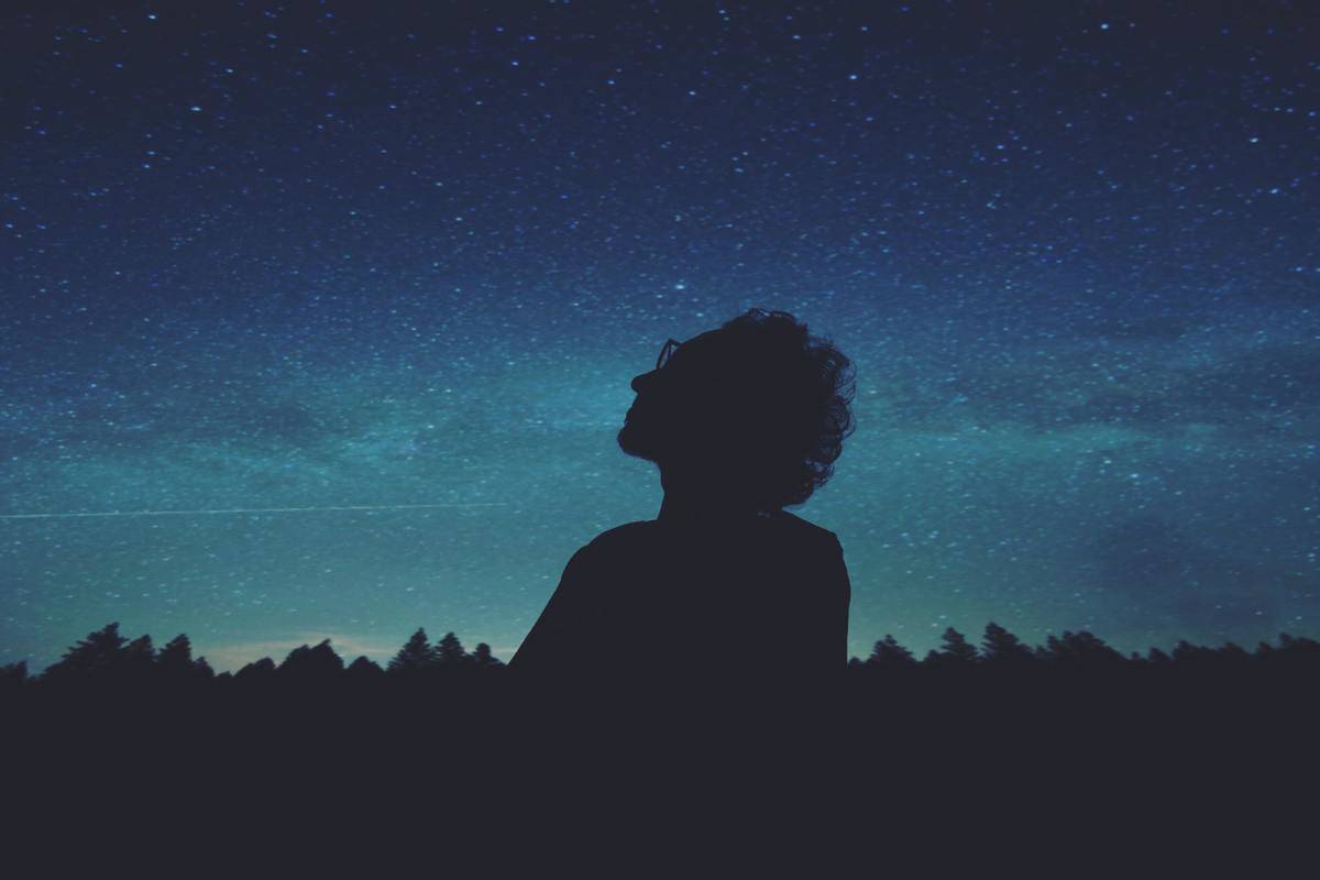 silhouette of woman looking at the stars
