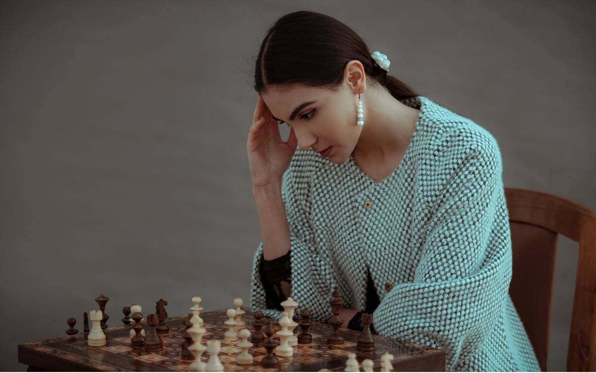 ePnsive-ethnic-woman-thinking-on-chess-move-