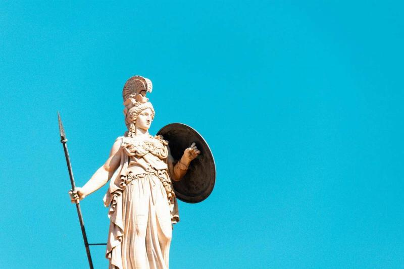 A statue of Athena holding a sword and armor.