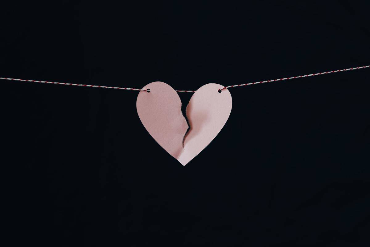 A broken heart made out of construction paper, hanging on a string.