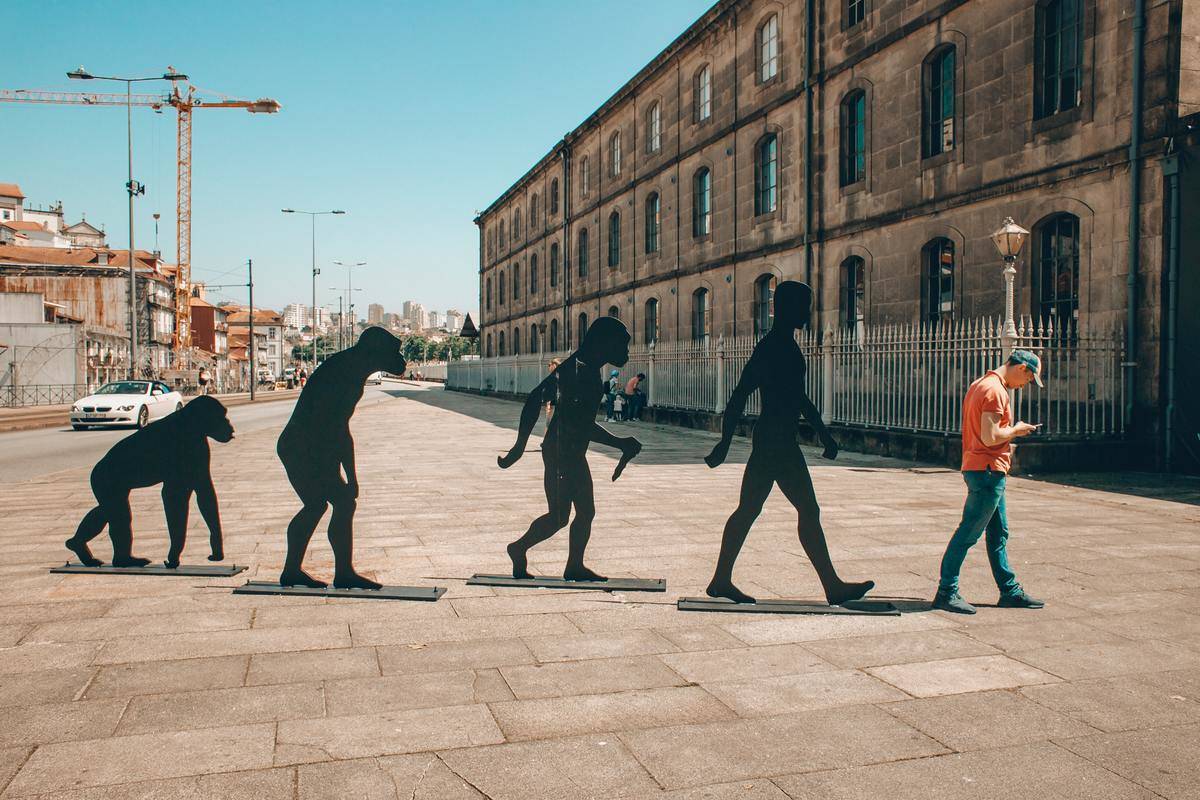 The stages of human evolution shown in front of a modern-day city.
