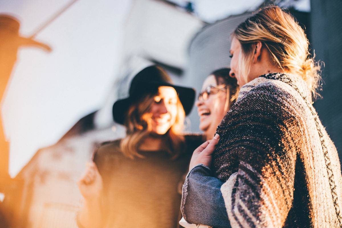 Three women laughing together.