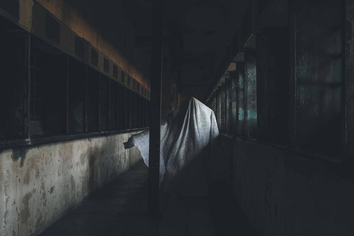 A ghostly figure in a dark jail cell.