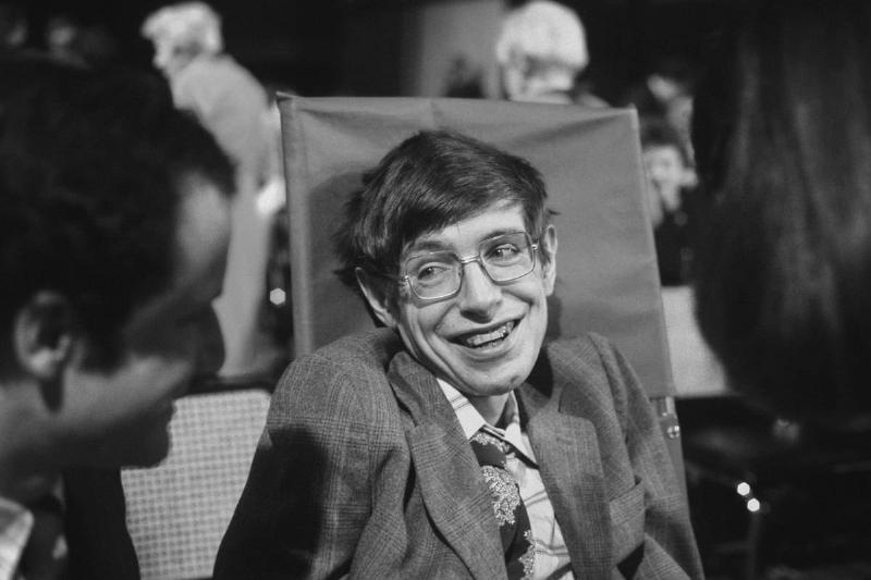 A Black and white photo of Stephen Hawking smiling.