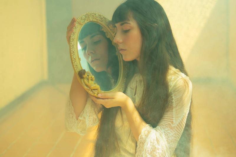 oung-girl-with-long-black-hair-looking-in-mirror