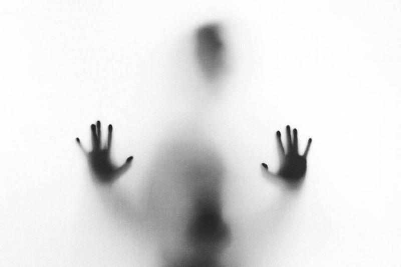 A person leaning their hands against a fogged-out window.