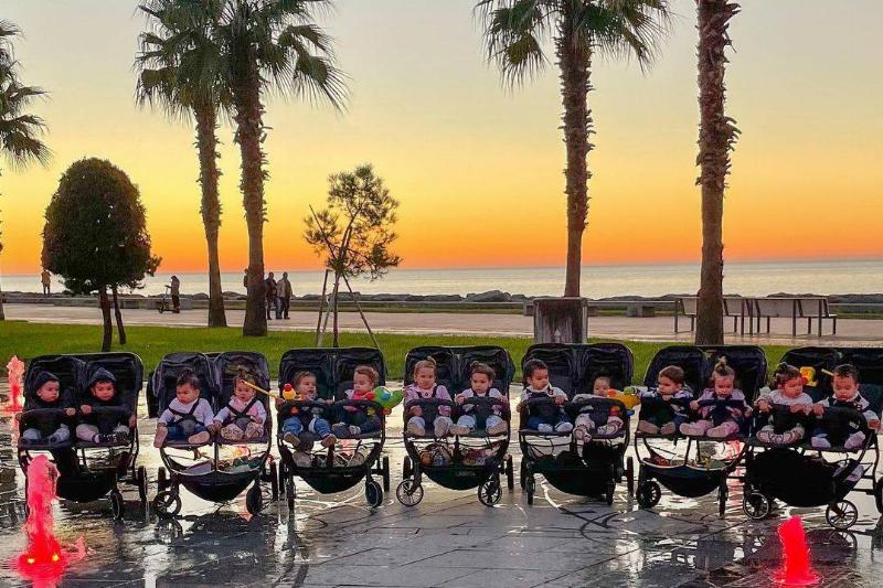 21 babies in strollers by beach sunset