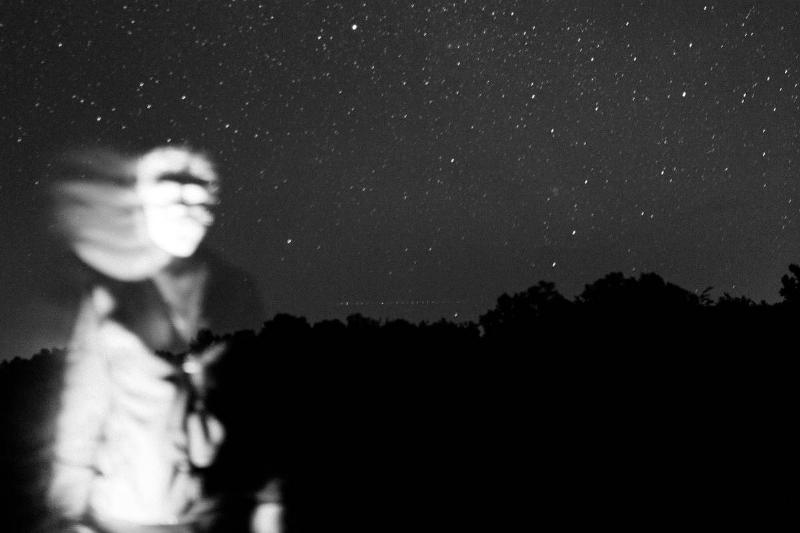 ghostly figure in starry sky with hair flowing in black and white