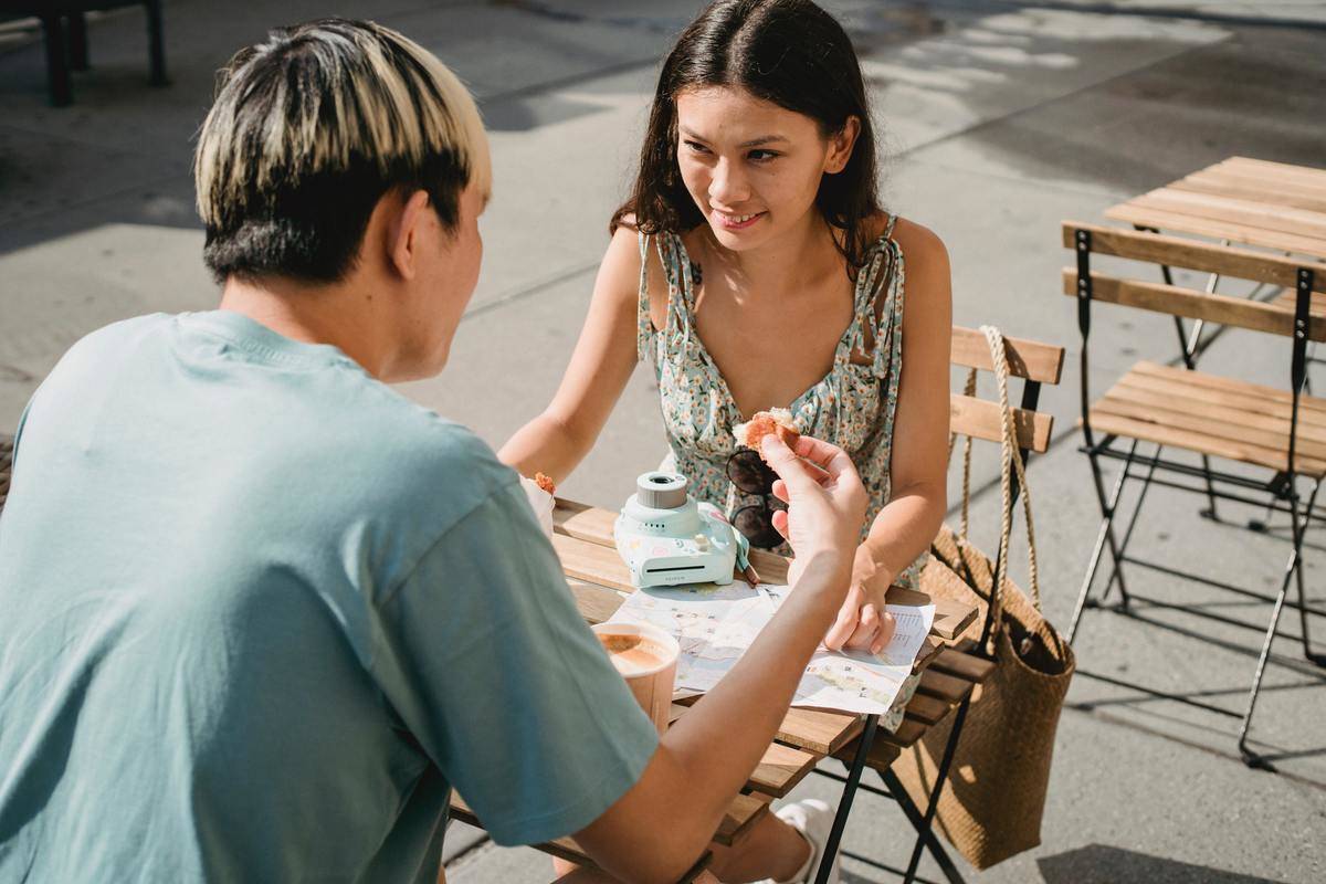 man and woman sit at table talking